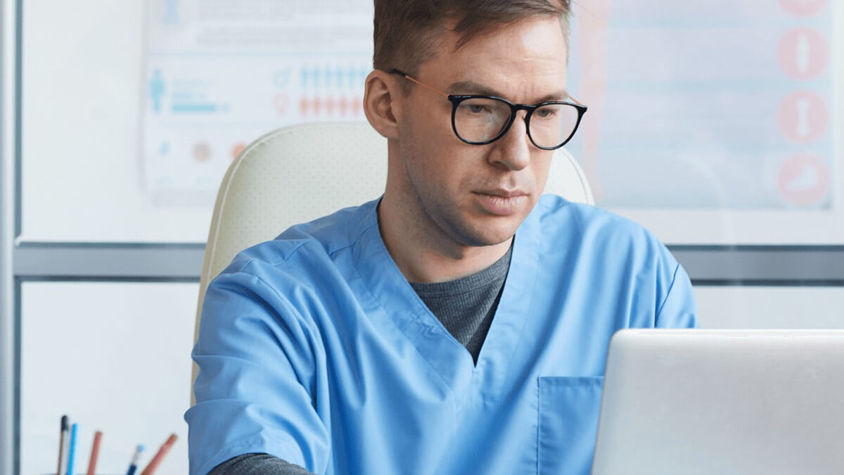 a male doctor works on his laptop