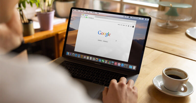 A man uses a browser window to open Google on his laptop