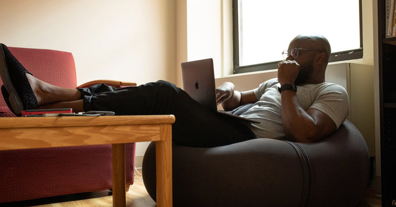 Man lounging on a bean bag with his legs on a coffee table